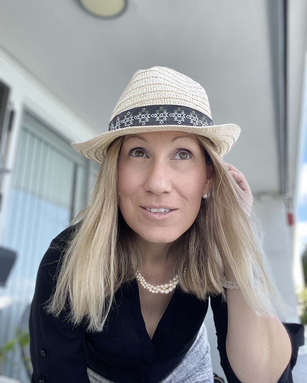 JoJo, founder of Wildfeathershops, wearing a straw hat